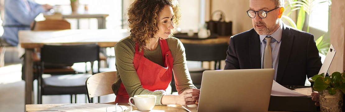 A business owner meeting with her financial advisor in her cafe.